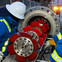 Workers in safety gear inspect a pipeline pigging tool at an industrial site.