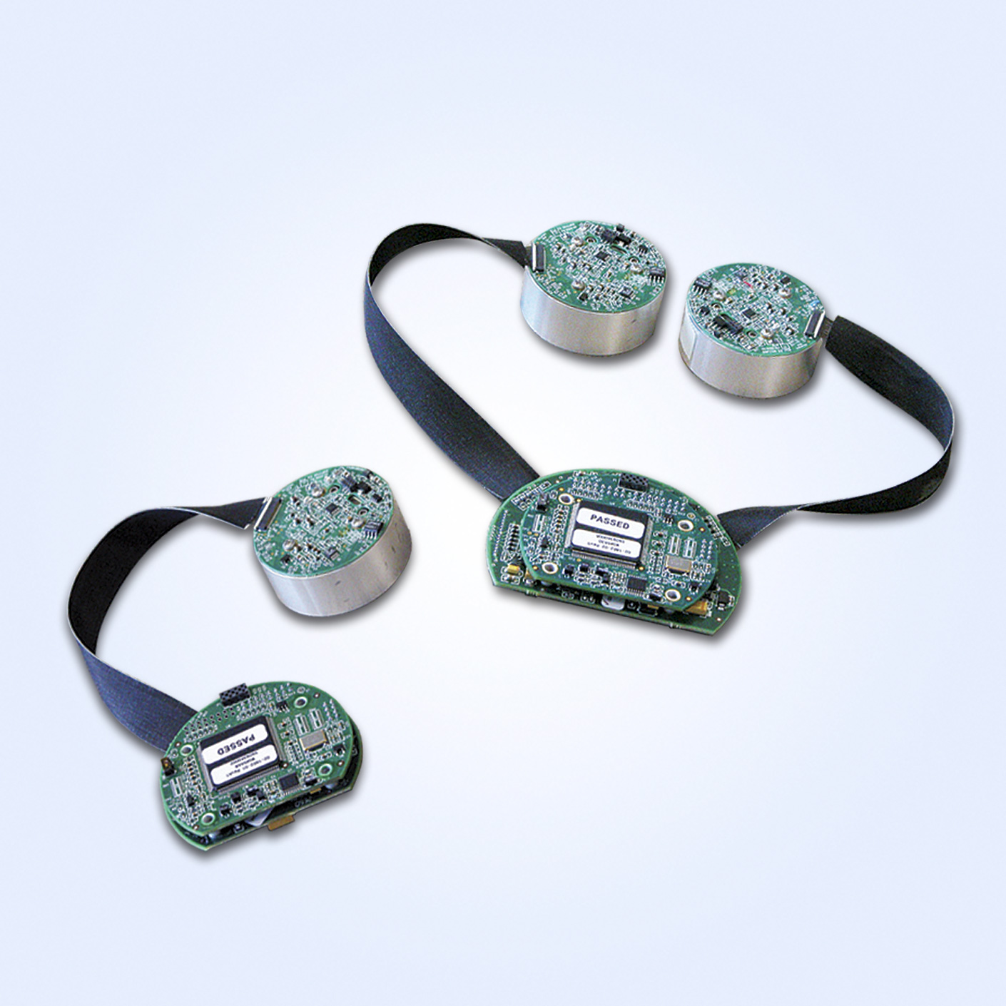 Electronic circuit boards with black straps, showcasing intricate components and "PASSED" labels.