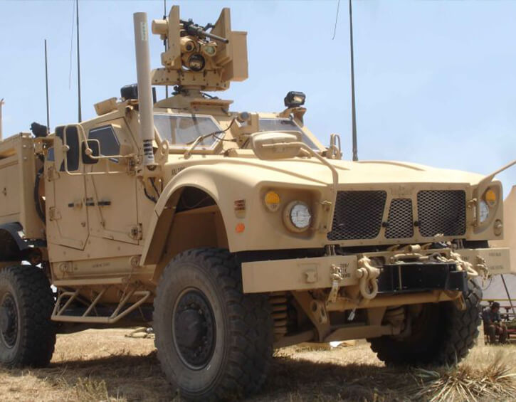 A tan military vehicle equipped with advanced weaponry and communication systems.