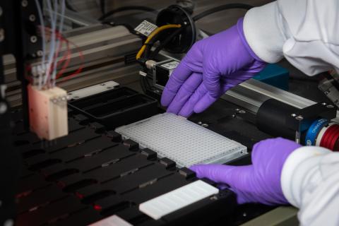 Erin Rosenberger sets up BioDot’s Rainmaker picoliter dispensing system for DNA microarray printing. Draper is developing the custom mini-microarray device to detect many genetic signatures from precious samples.