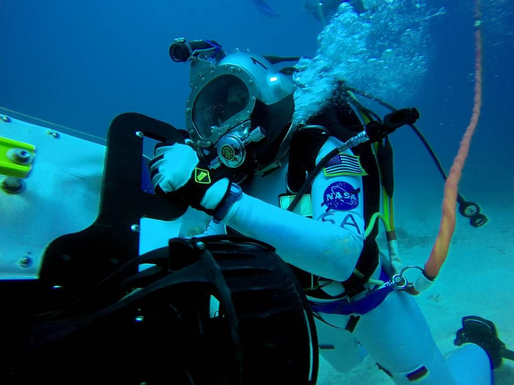 An aquanaut uses equipment under water