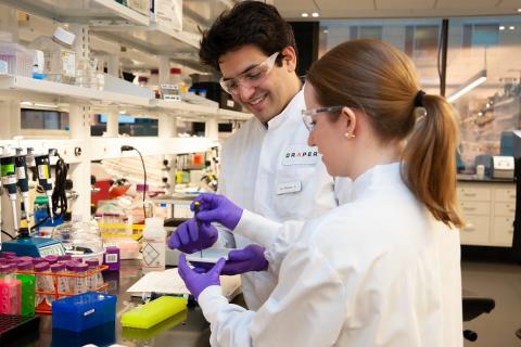 Draper engineers Charles Lissandrello and Erin Rosenberger of the Biological Microsystems group configure a device for detecting bioengineered organisms. Draper is under contract with the Office of the Director of National Intelligence to develop the device.