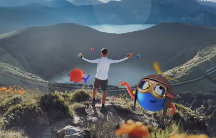 man on a mountain with hands raised in the air