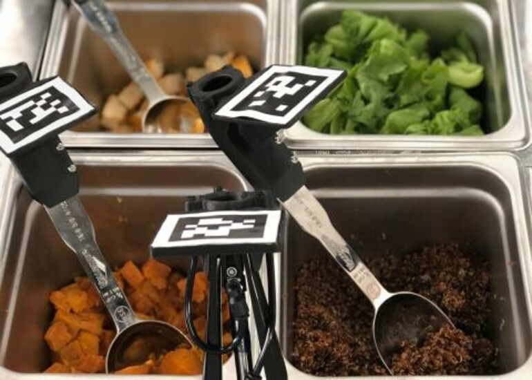 Serving utensils in food containers with QR type codes on the handles