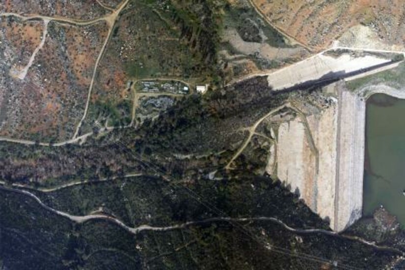 Aerial view of a landscape with roads, vegetation, and a body of water, showcasing satellite imagery.