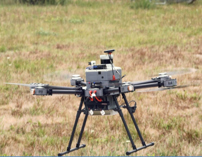 A drone hovers over a grassy field, showcasing advanced technology for aerial surveillance.