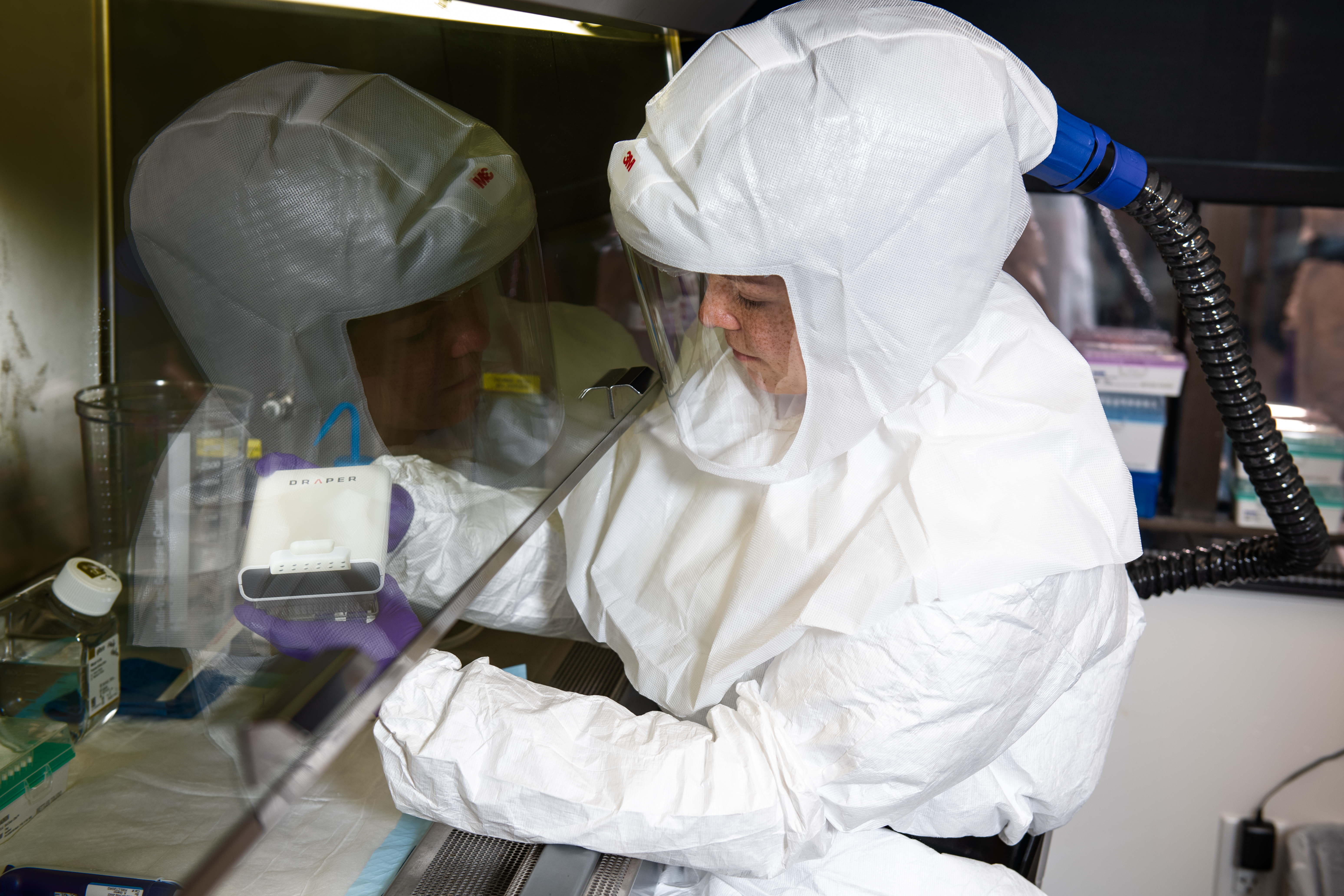 Draper’s Christine Fisher, Ph.D., works with the PREDICT96 in a biosafety level 3 (BSL-3) laboratory.