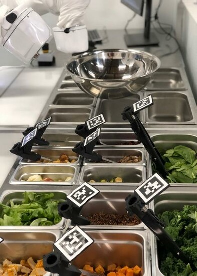 A robotic arm prepares a salad by recognizing and locating various ingredients in a kitchen setting.
