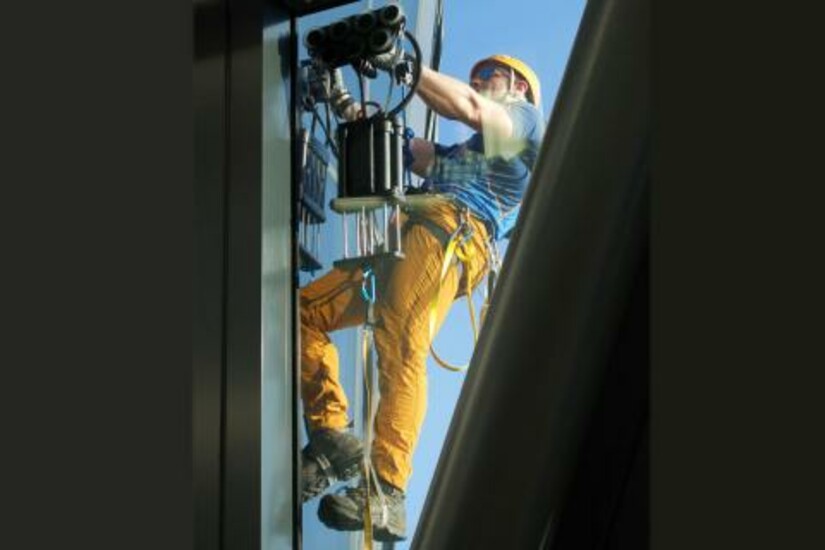 Andy Torbet climbs a tall office building using Draper's Z-Man system
