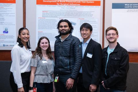 The student team (left to right)—Prinjali Kalyan, Felicia Pinto, Aniket Joshi and Brian Zhou, joined here by Draper Advisor Joseph Urban—presents research at the Draper Research Symposium. They developed a burst pressure testing system for surgical adhesives related to Draper’s pediatric heart valve program. The students are Bachelor of Science degree candidates in Boston University’s Biomedical Engineering program. Not pictured is Beau Landis, Draper Advisor. Credit: Draper.