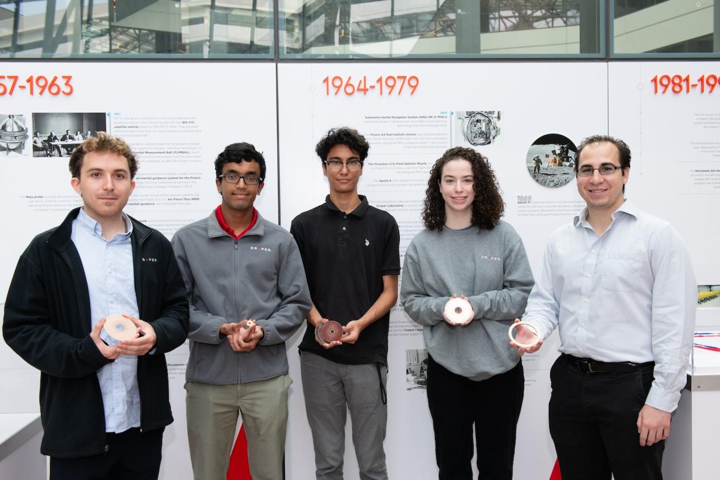 Karthik Shaji, Julie Katz, Nick Ghaffarian, Lucas Dahlke, and Michael D'Agati hold pieces of a motor