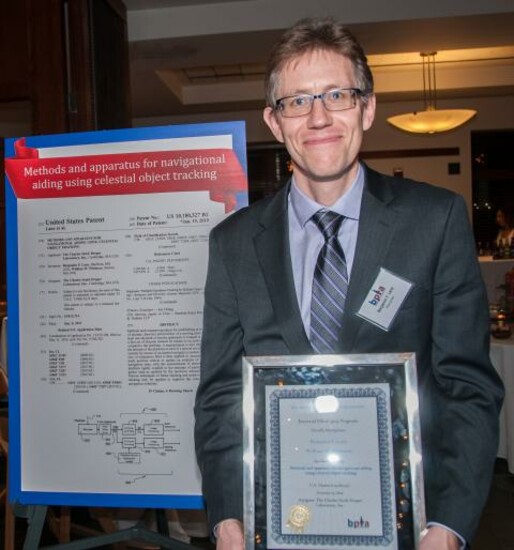 Ben Lane with the award for celestial navigation system patent at the Invented Here! ceremony.