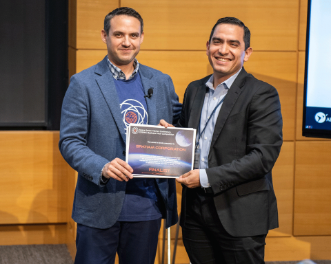 Dustin Martin of Draper congratulates Alberto Montilla of Spatiam Corporation as a finalist at the COSMIC Pitch Competition during the Space Sector Market Conference. Credit: Draper.