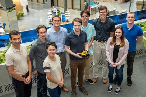 Draper’s Team Ductboat members are (left to right) Daniel Rossetti (advisor), Jared Breton, Kasandra Yee, Kevin Shoyer, Jeremy Spear, Linden Vo, Jacob T. (JT) McGuire, Aisling McEleney and Eric Holtzman (advisor). They launched their hovercraft inside Draper’s Atrium this summer.