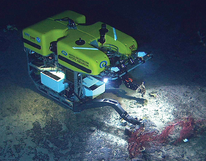 Underwater ROV exploring the ocean floor with robotic arms and bright lights.