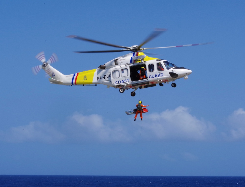 Helicopter with man being lowered down with a stretcher