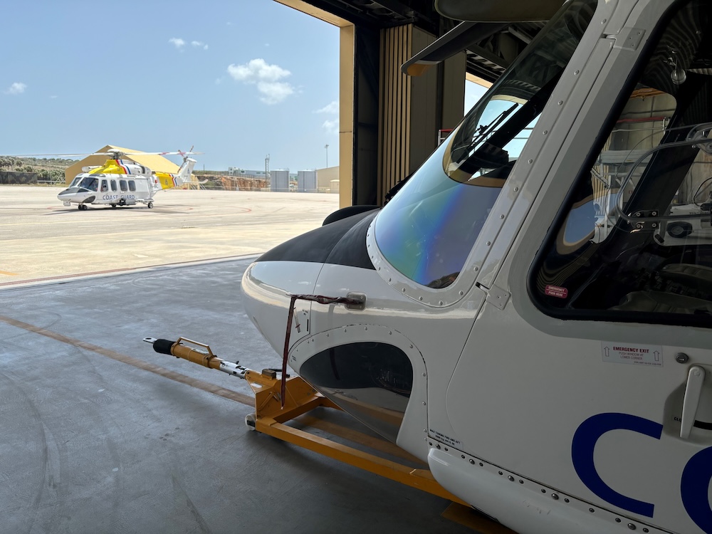 View looking out a hanger with a helicopter on the tarmac
