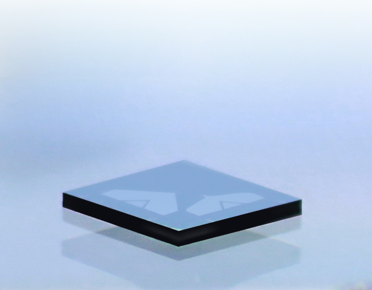 A blue computer chip with black edges resting on a reflective surface.