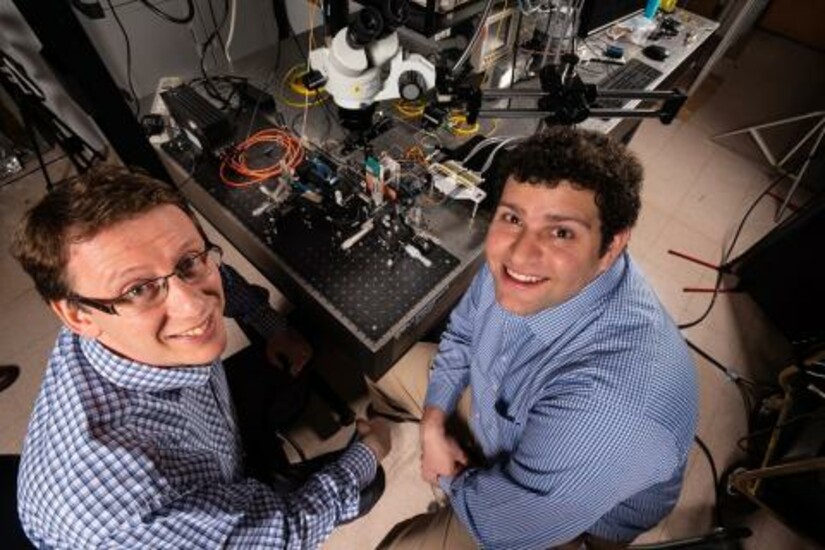 Two engineers from Draper working on the new LiDAR-on-a-Chip technology in their lab.