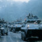 Military vehicles and soldiers navigate a muddy forest path, ready for action in a dense jungle setting.