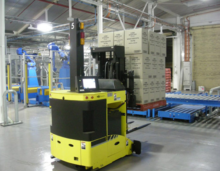 Automated forklift transporting stacked boxes in a modern warehouse.