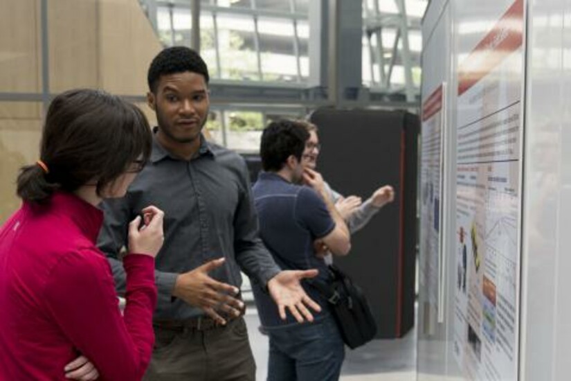 Attendees engage in discussions during the poster sessions at the event.