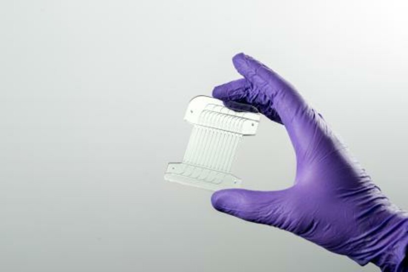 A gloved hand holds Draper's Acoustic Enrichment Module