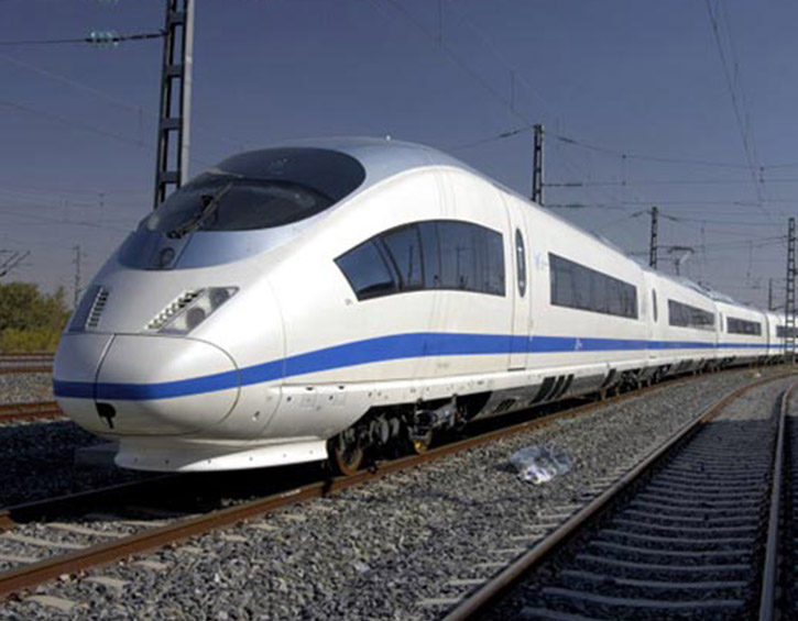 Sleek white high-speed train on tracks under a clear blue sky.