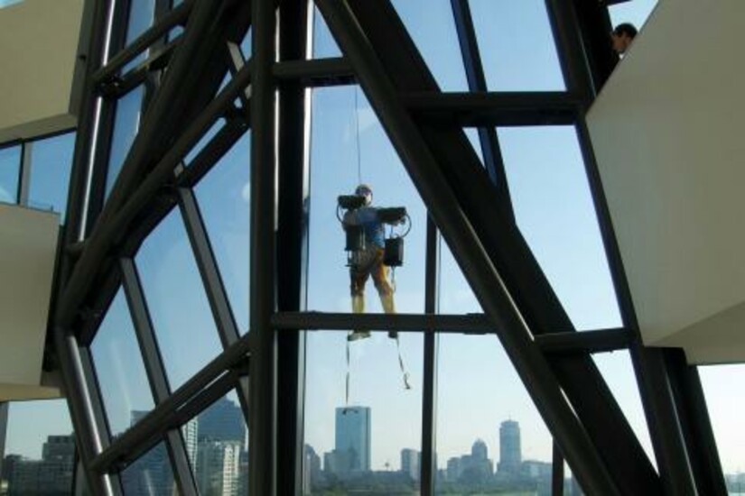 A person using a climbing system on a glass building using the Z-Man system