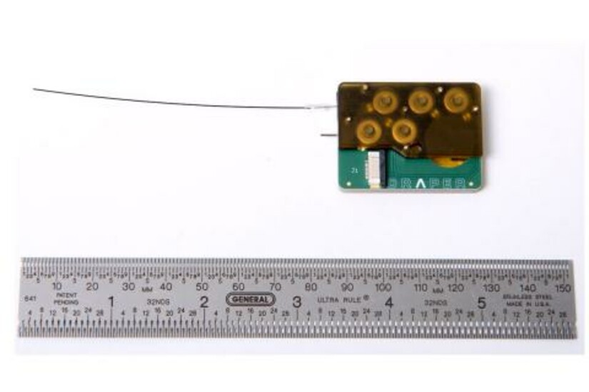 Draper’s device for intracochlear drug delivery, shown next to a ruler for scale.