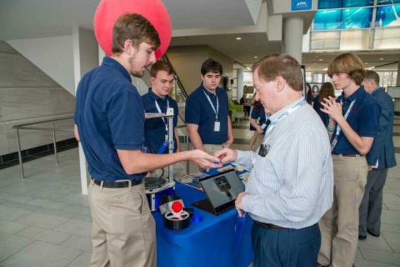 High school students present their project to a visitor