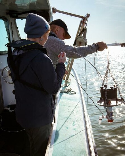 EPA Region 9 team members prepare to take water samples while on a boat.