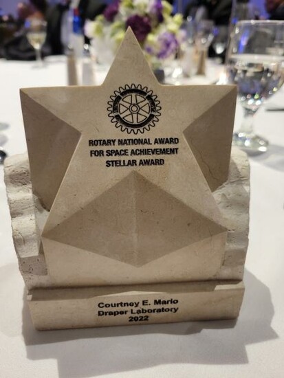 Rotary National Award for Space Achievement Stellar Award trophy on a table with flowers and glasses.