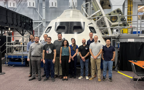 Draper's Houston Team at the NASA Space Vehicle Mockup Facility in front of an Orion mockup.Pictured left to right: Carl De Vries (intern), Nicklaus (Nick) Richardson, Stephen Steffes, Kyle Smith, Christopher (Chris) Ertl (intern), Lylia Benhacine, Kari Ward, Javier Doll, Peter Schulte, Adam Leingang and Barin Moghimi (intern).