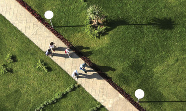 Photo looking down at a paved path with five people walking.