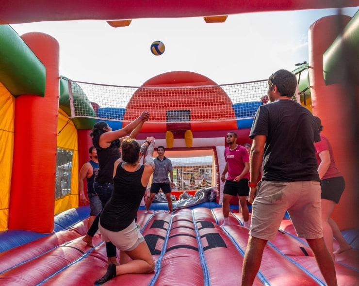 Employees playing volleyball in a bounce house