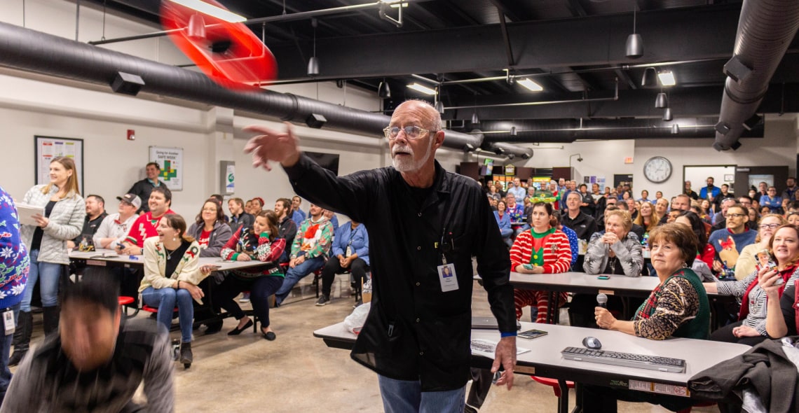 Employee tossing a red object during meeting