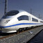 Sleek white high-speed train on tracks under a clear blue sky.