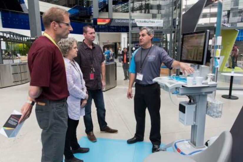 A Draper representative explains the microAnalyzer™ to a group 