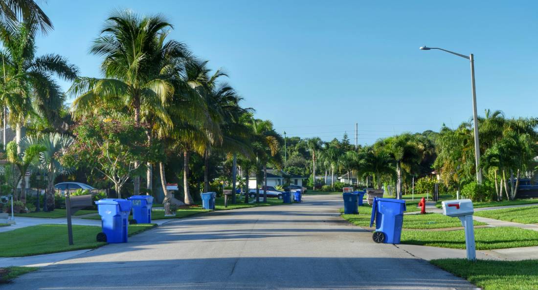 Neighborhood street, with blue trash cans set outside