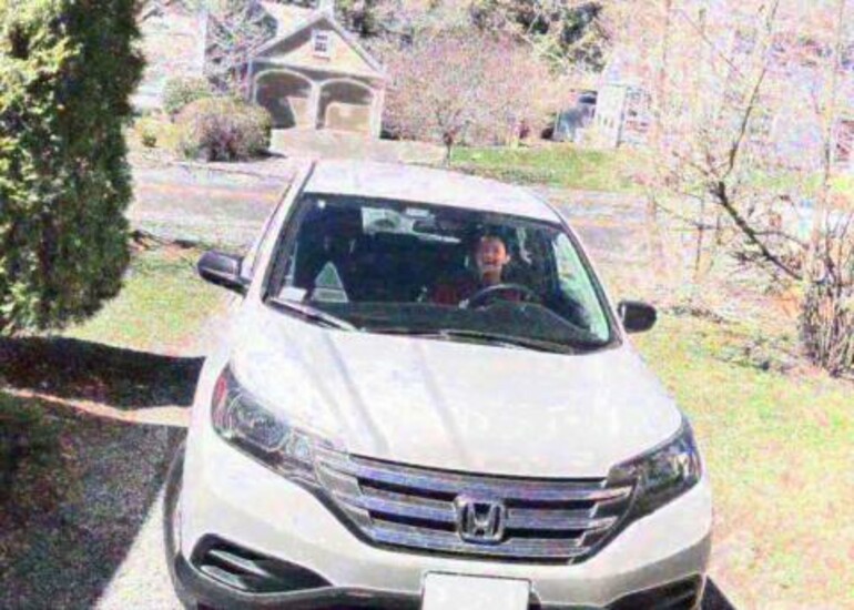 A car parked in a driveway with a person inside, demonstrating video deconfounding technology.
