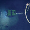 Underwater ROV exploring the ocean floor with a tether cable and light illuminating the surroundings.
