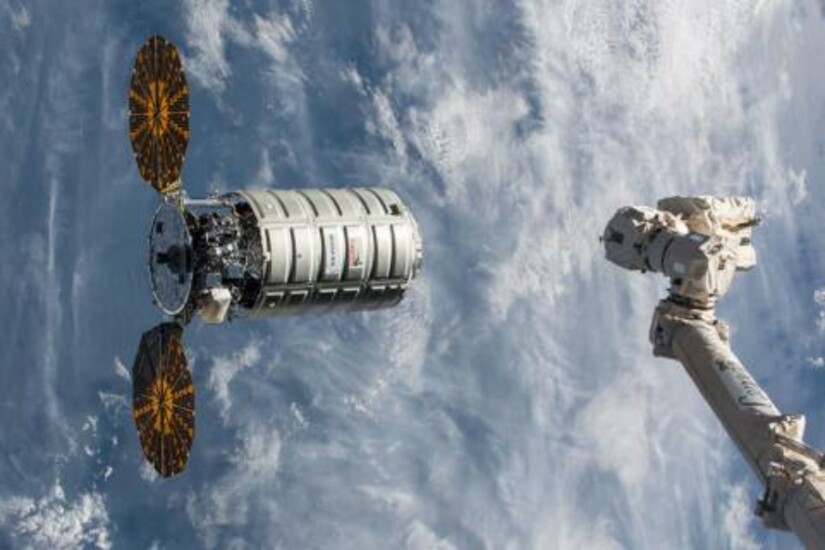 Cygnus OA-8 spacecraft approaches the International Space Station with robotic arm visible.