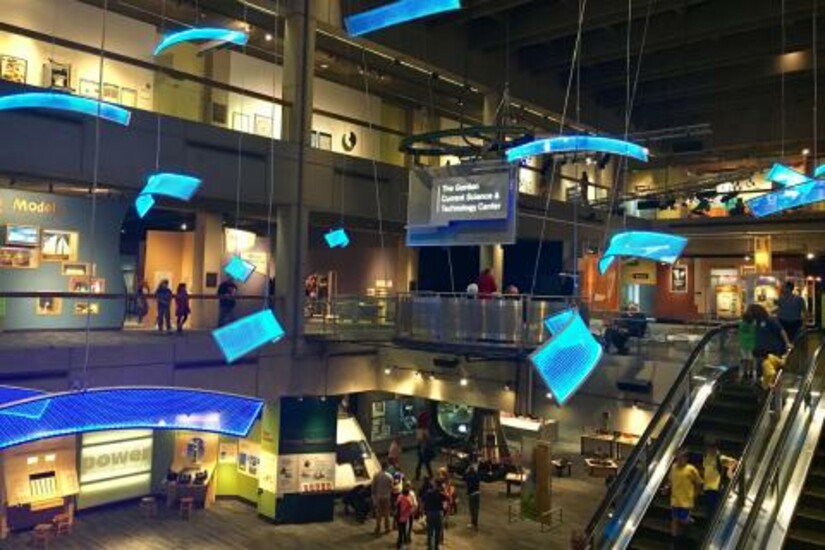3-story interior with blue-lit art pieces hanging from the ceiling