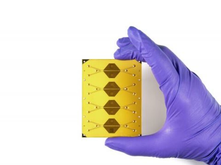 A gloved hand holds Draper’s Microfluidic Continuous Electroporation Module.