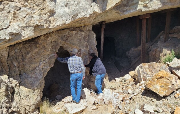 Men looking in rocky cave