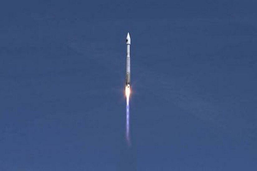 Atlas V rocket with Cygnus cargo module launches from Cape Canaveral, Florida against a clear sky.