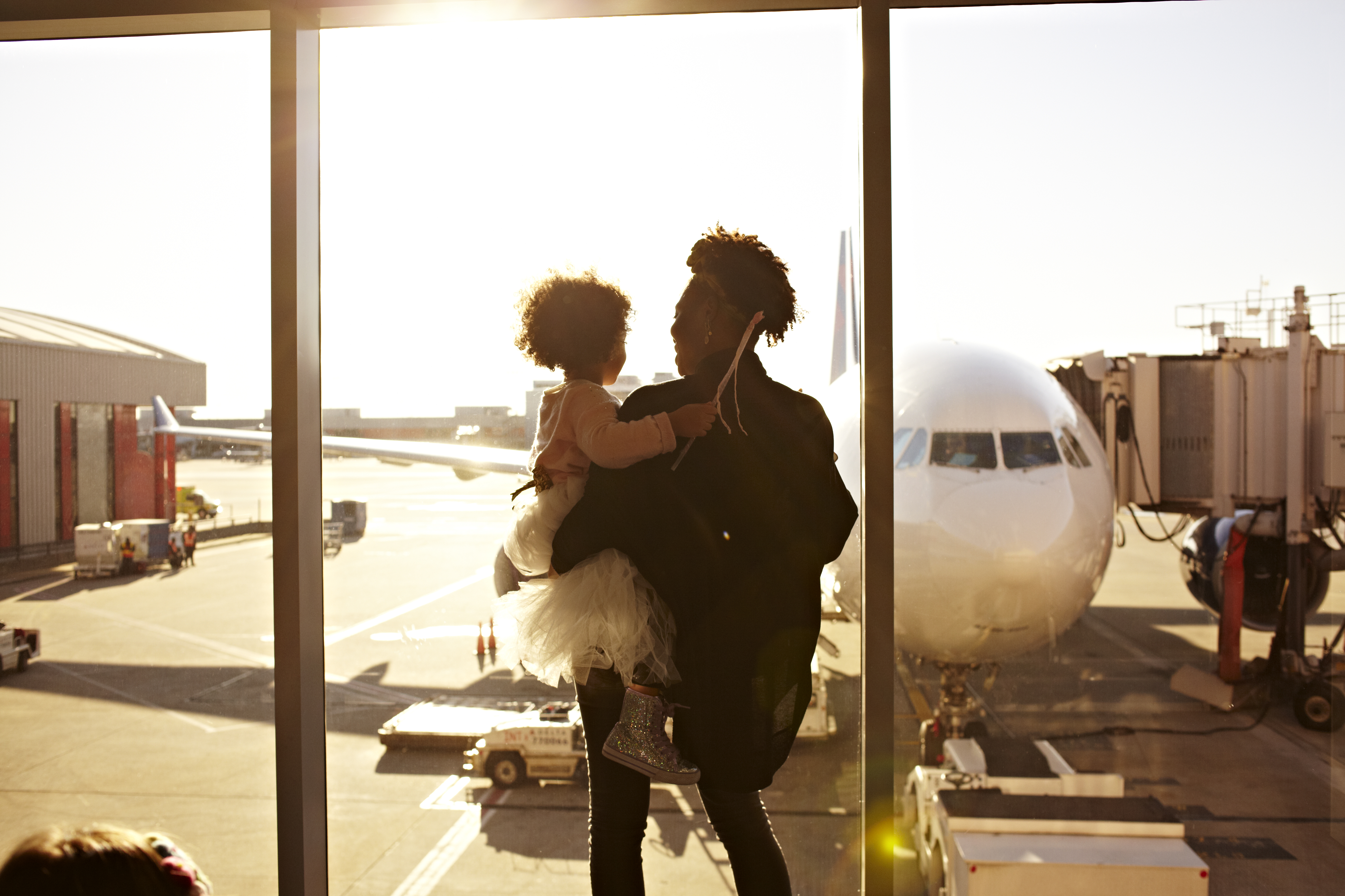 A parent holding their child at an airport terminal
